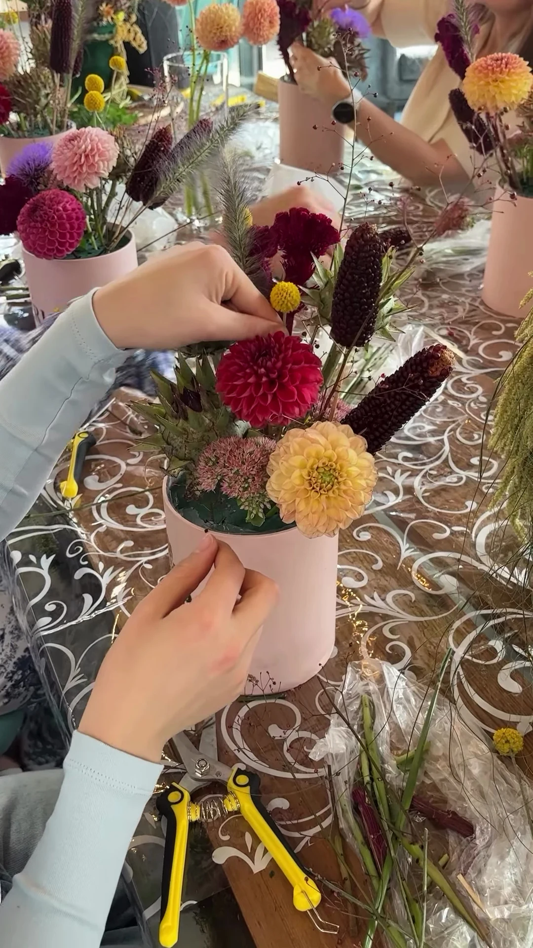 Руки учасниці під час створення осінньої композиції